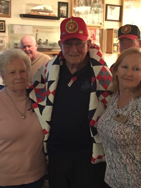 Julie Larson, Calabash VFW Auxiliary member, and Cathy Elliott, Quilt of Valor Foundation member, present a quilt to Richie Murray at the Marine Corp birthday celebration at VFW Calabash Post #7288.